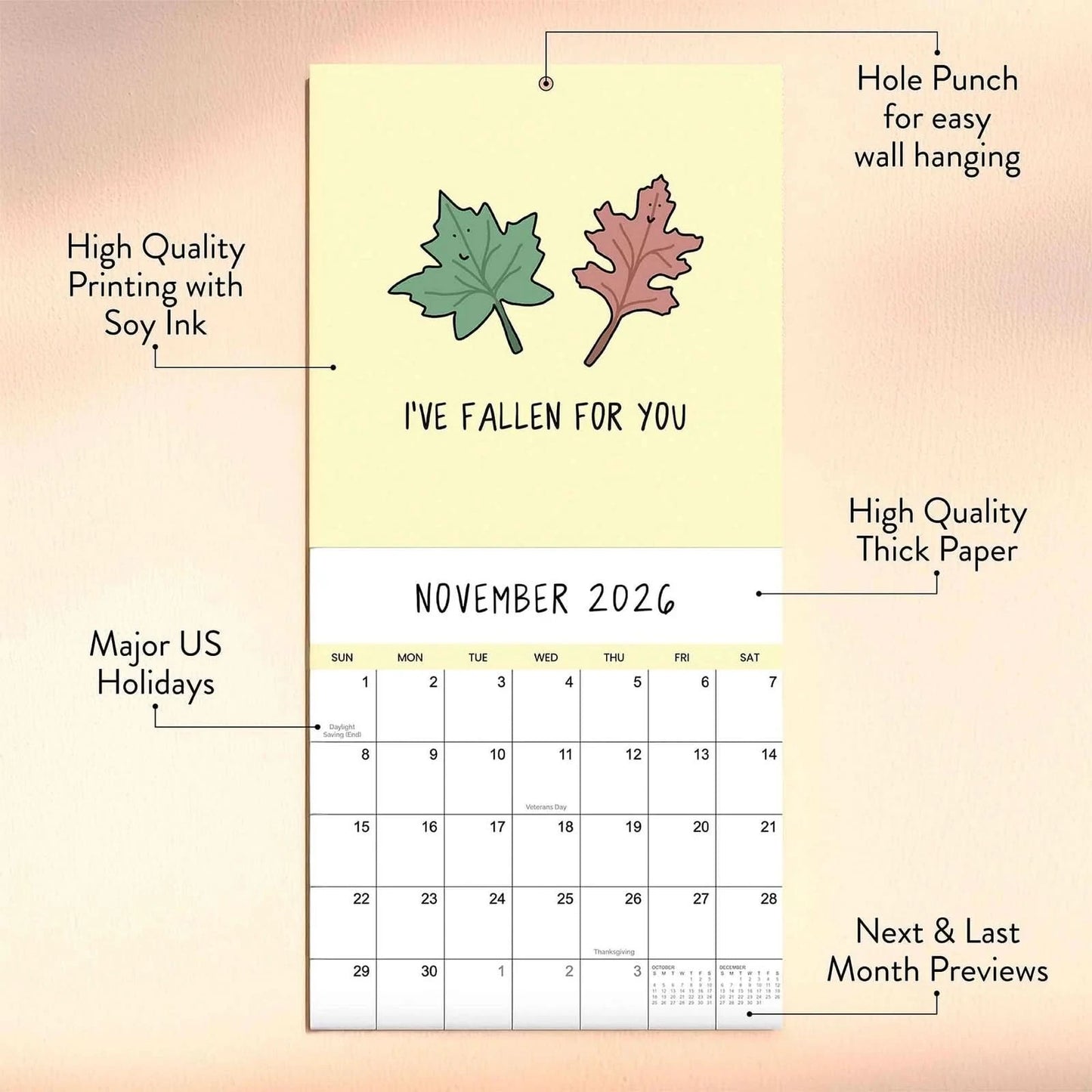 The 2026 Wall Calendar "You've Got To Be Yolking" by rockdoodles is open to November, showing two autumn leaves and features soy ink, thick paper, month previews, major US holidays, hole punch—classic rockdoodles style.