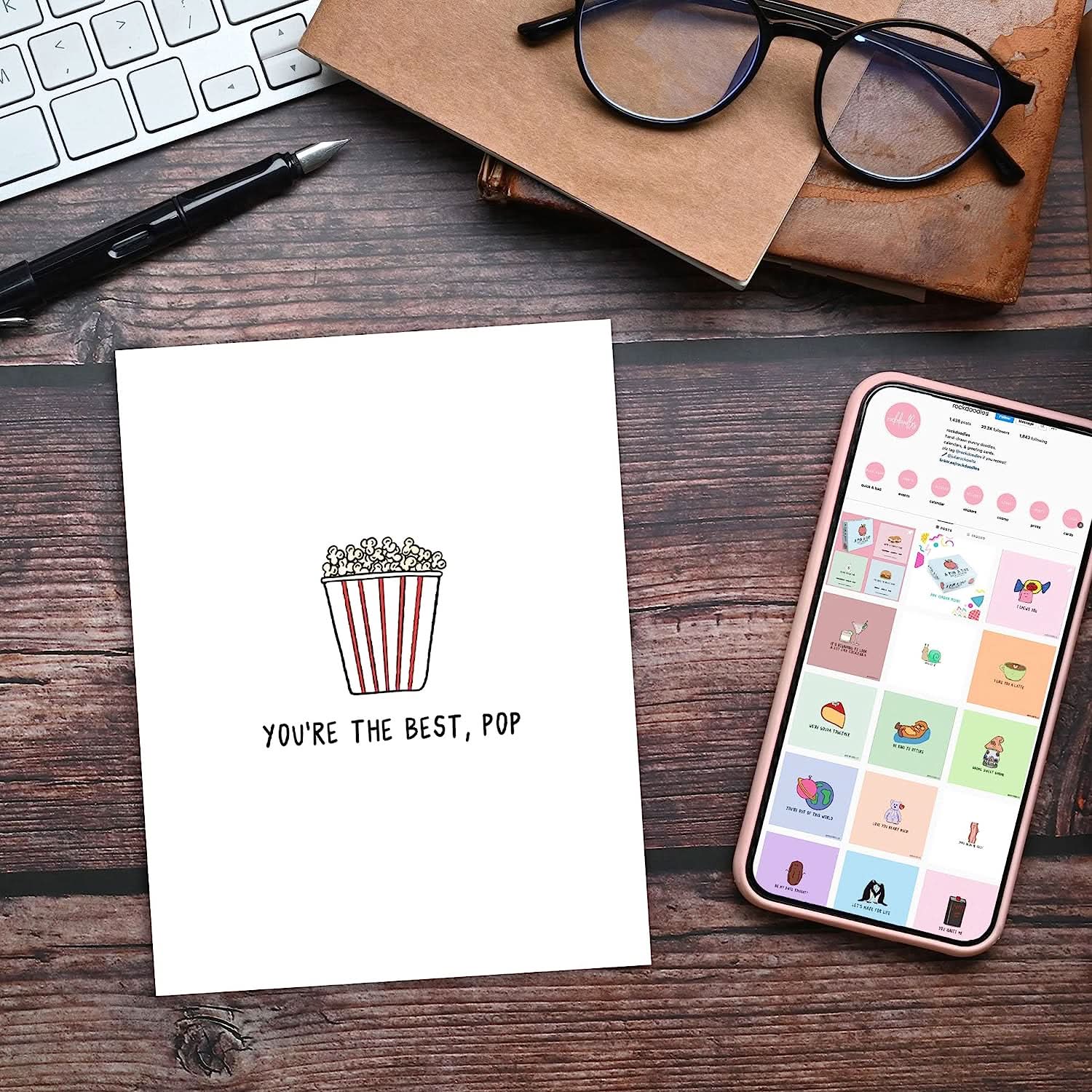 The rockdoodles Best Pop Card accompanied by a phone and a bowl of popcorn for the perfect movie night.
