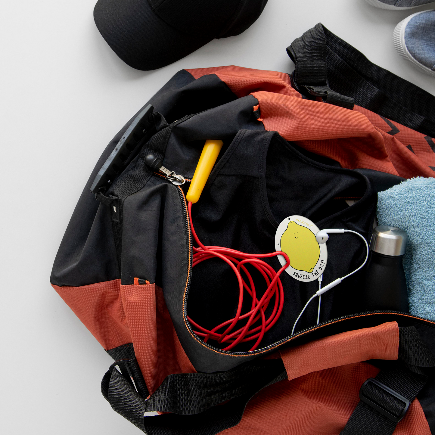 The contents of a sports bag featuring Squeeze The Day (2-Pack) Punny Air Fresheners - Lemon Scent on a white background from rockdoodles.