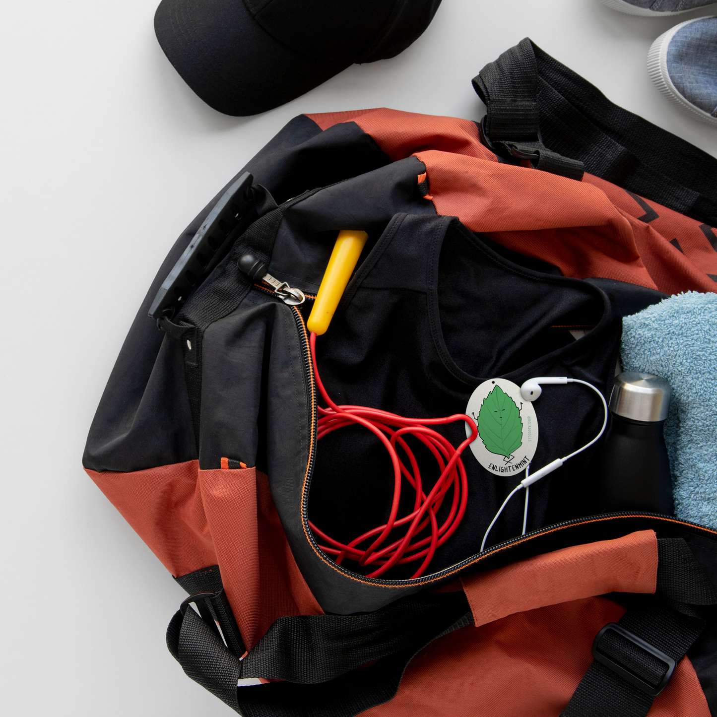 A 2-pack of Enlightenmint (2-Pack) Punny Air Fresheners - Fresh Peppermint Scent by rockdoodles inside a sports bag on a white background.