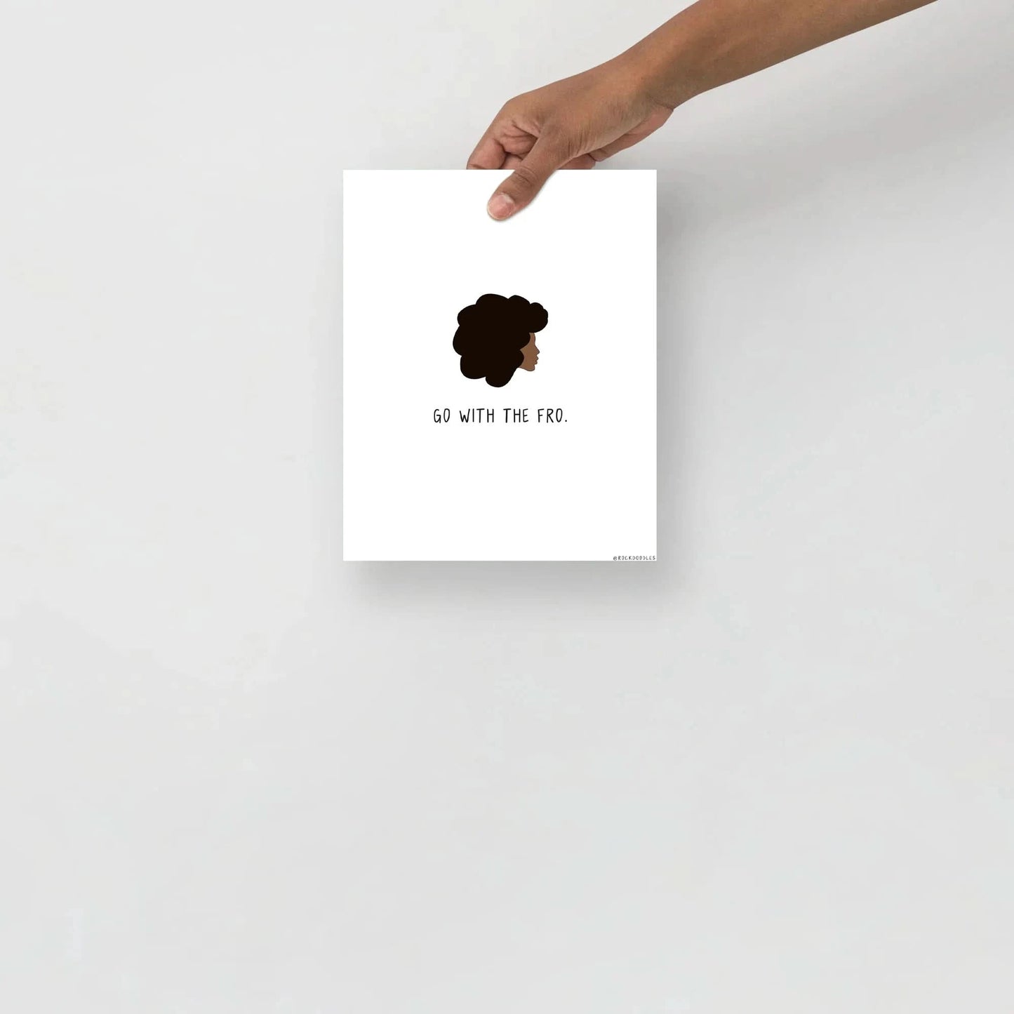 A hand holding up a Go With The Fro Print by rockdoodles with the words 'let me be me' on matte paper.