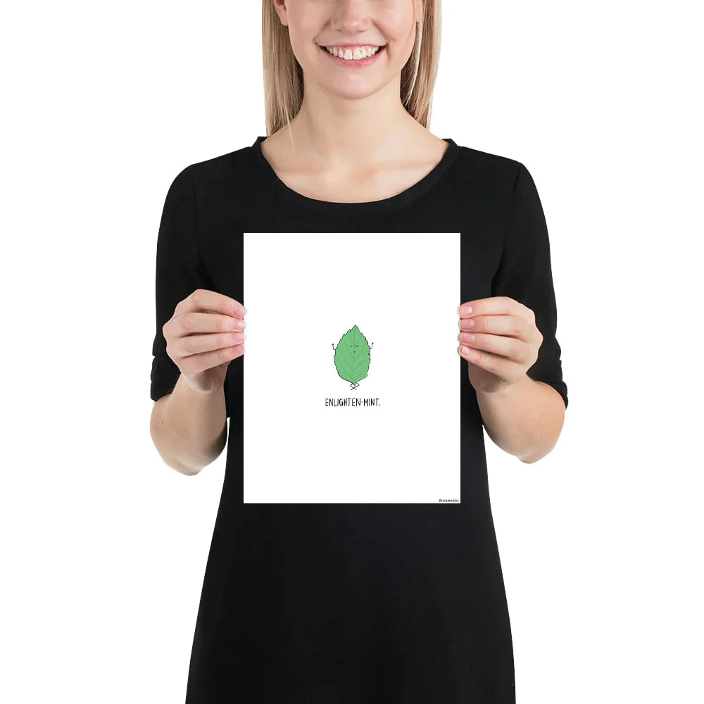A woman holding up a framed poster of an Enlightenmint Print by rockdoodles, which features a green leaf print on thick matte paper.