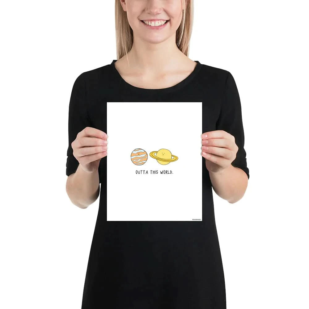 A woman holding a framed rockdoodles Outta This World Print.