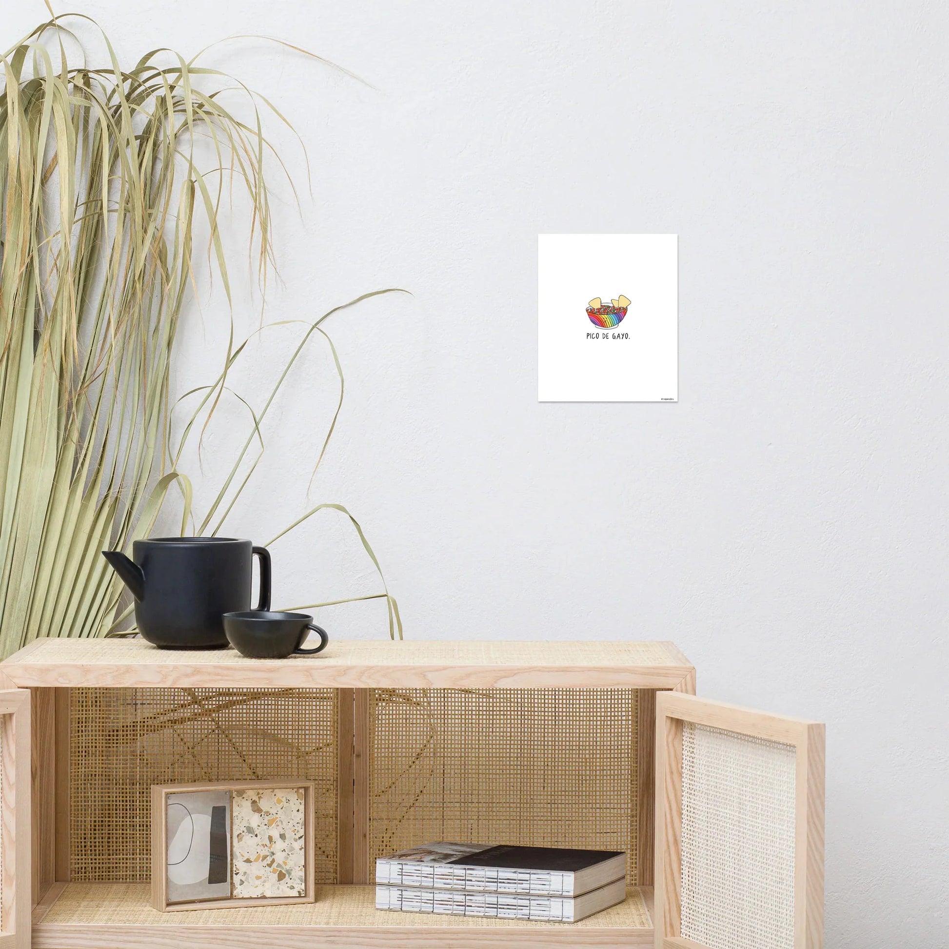 A living room with a coffee table and a plant on the wall, featuring a Pico De Gayo Print by rockdoodles in a wood frame.