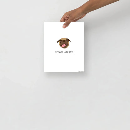 A hand holding a piece of rockdoodles matte paper with a Puggin Love You Print.