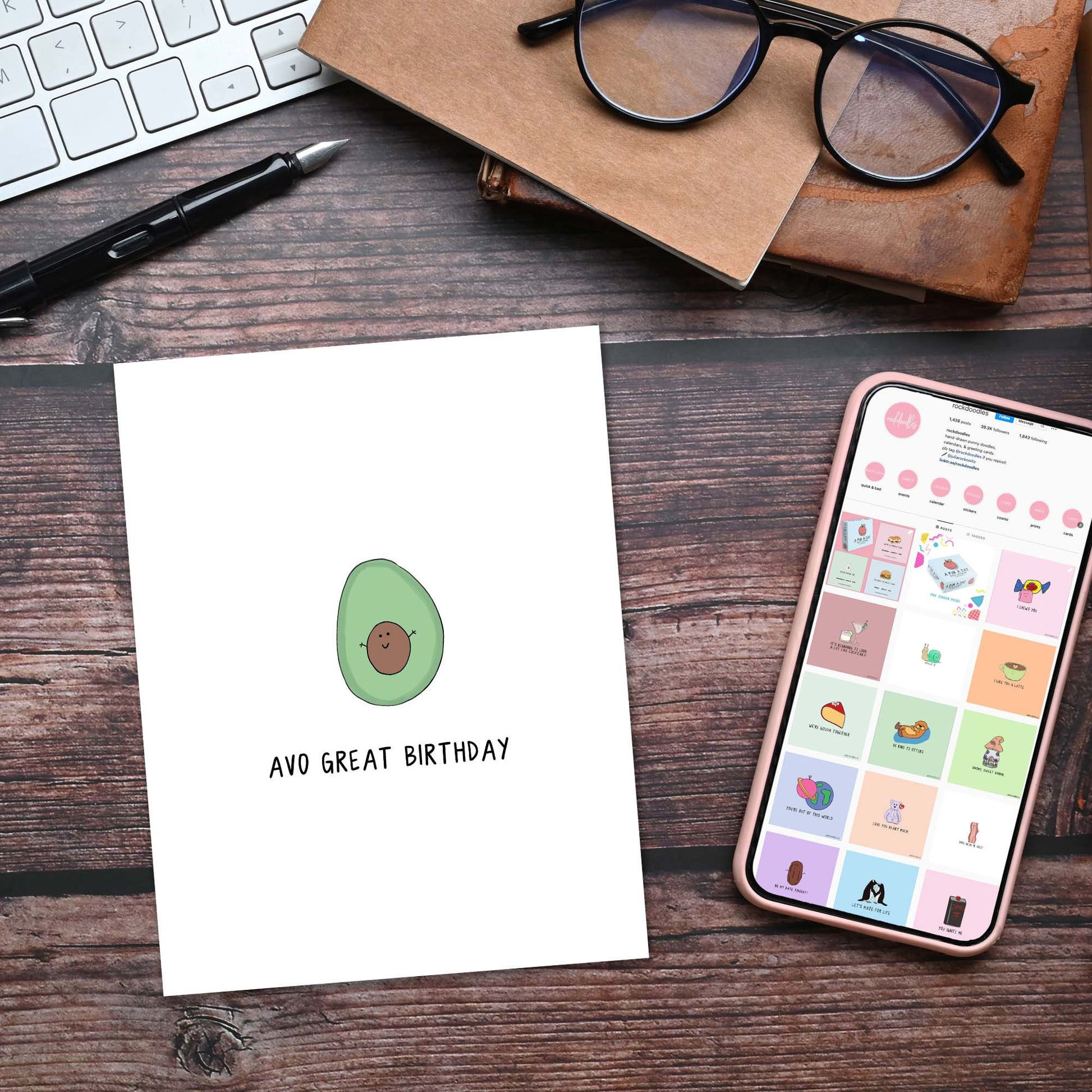 A birthday card with an avocado on it and a phone next to it. The perfect rockdoodles Avo Great Birthday Card birthday surprise!