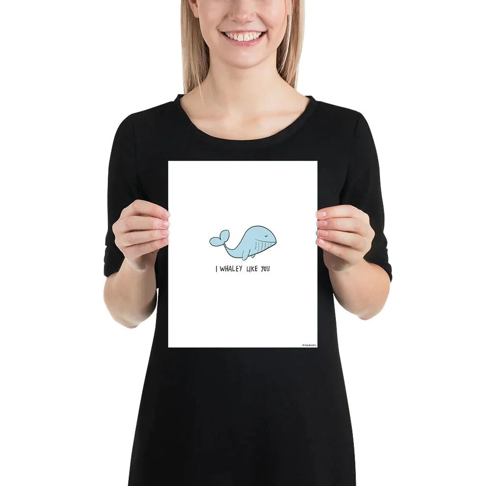 A woman holding up a framed poster of a rockdoodles I Whaley Like You Print on thick matte paper.
